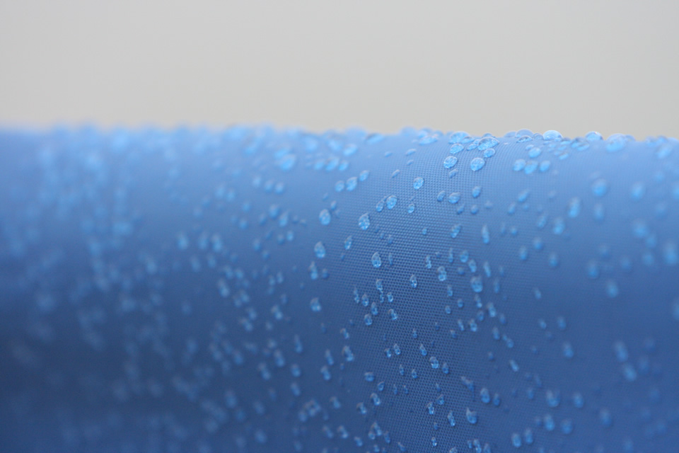 Rain drops on a blue plastic canvas