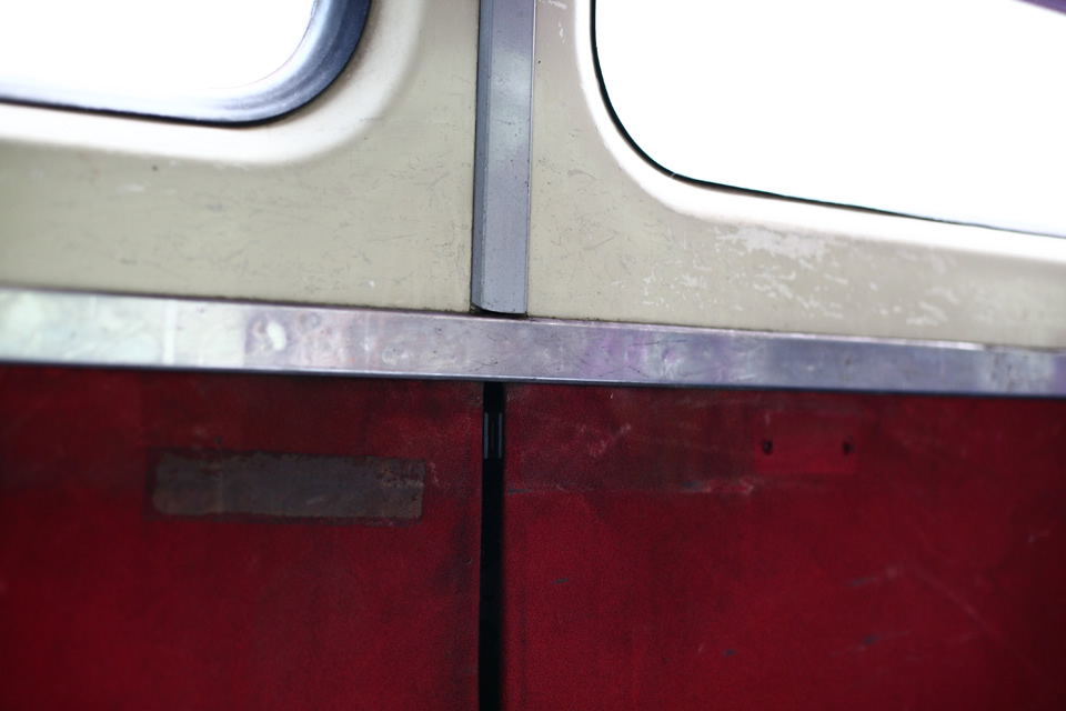 Red panelling and windows inside a train carriage